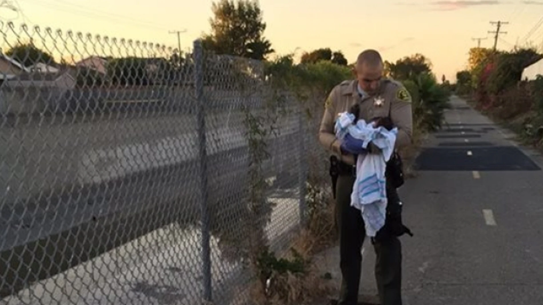 Un agente porta en sus brazos al bebé abandonado en Los Ángeles