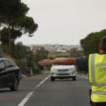 Un agente de la Guardia Civil detiene a un vehículo