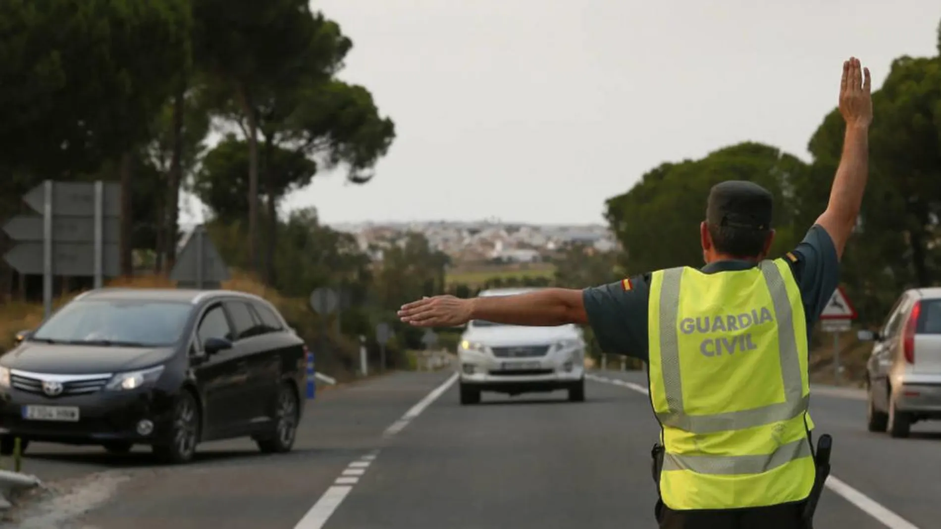 Un agente de la Guardia Civil detiene a un vehículo