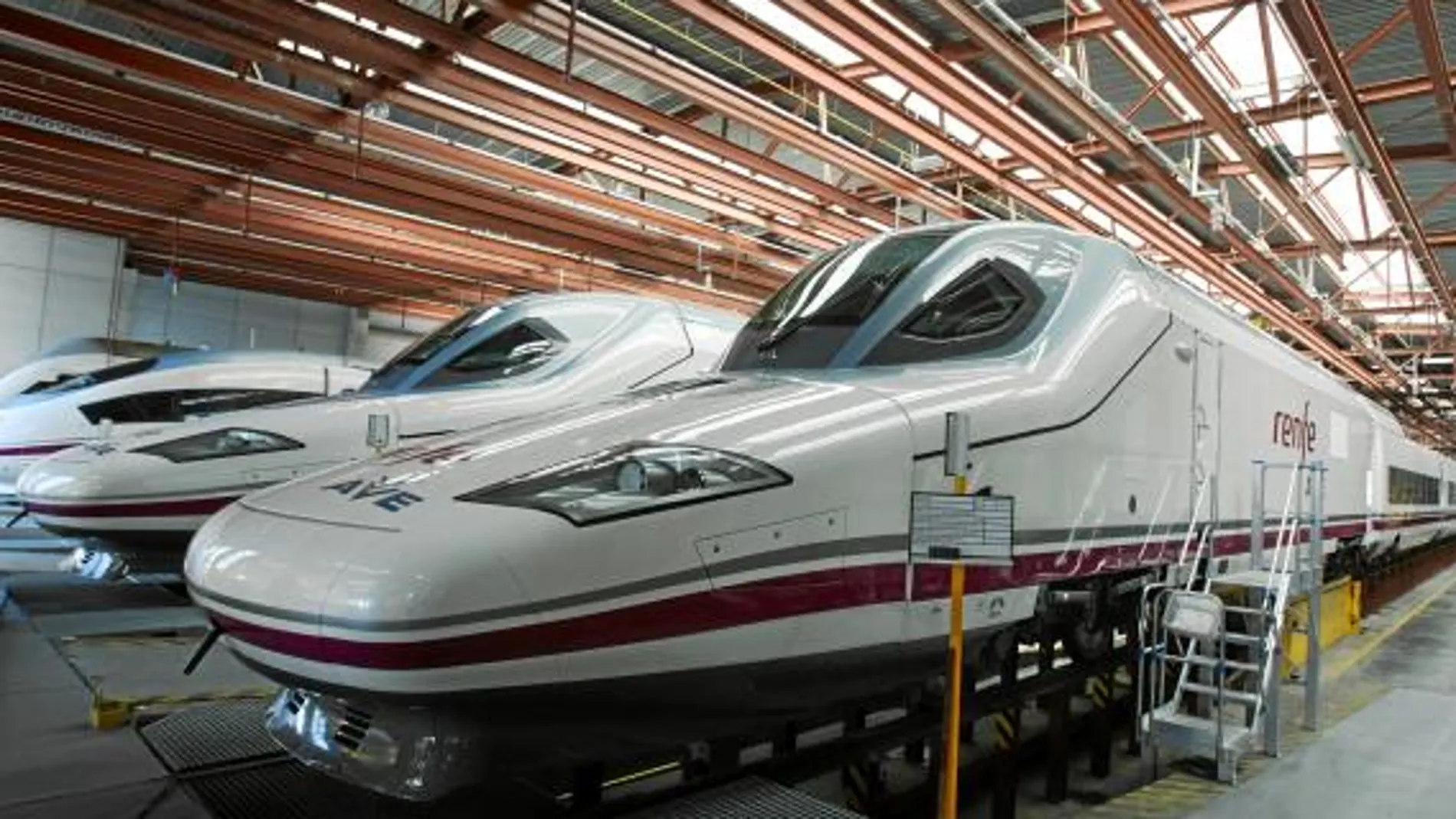 Tres trenes de Alta Velocidad esperan apacarcados en una estación española para comenzar su servicio de transporte de pasajeros