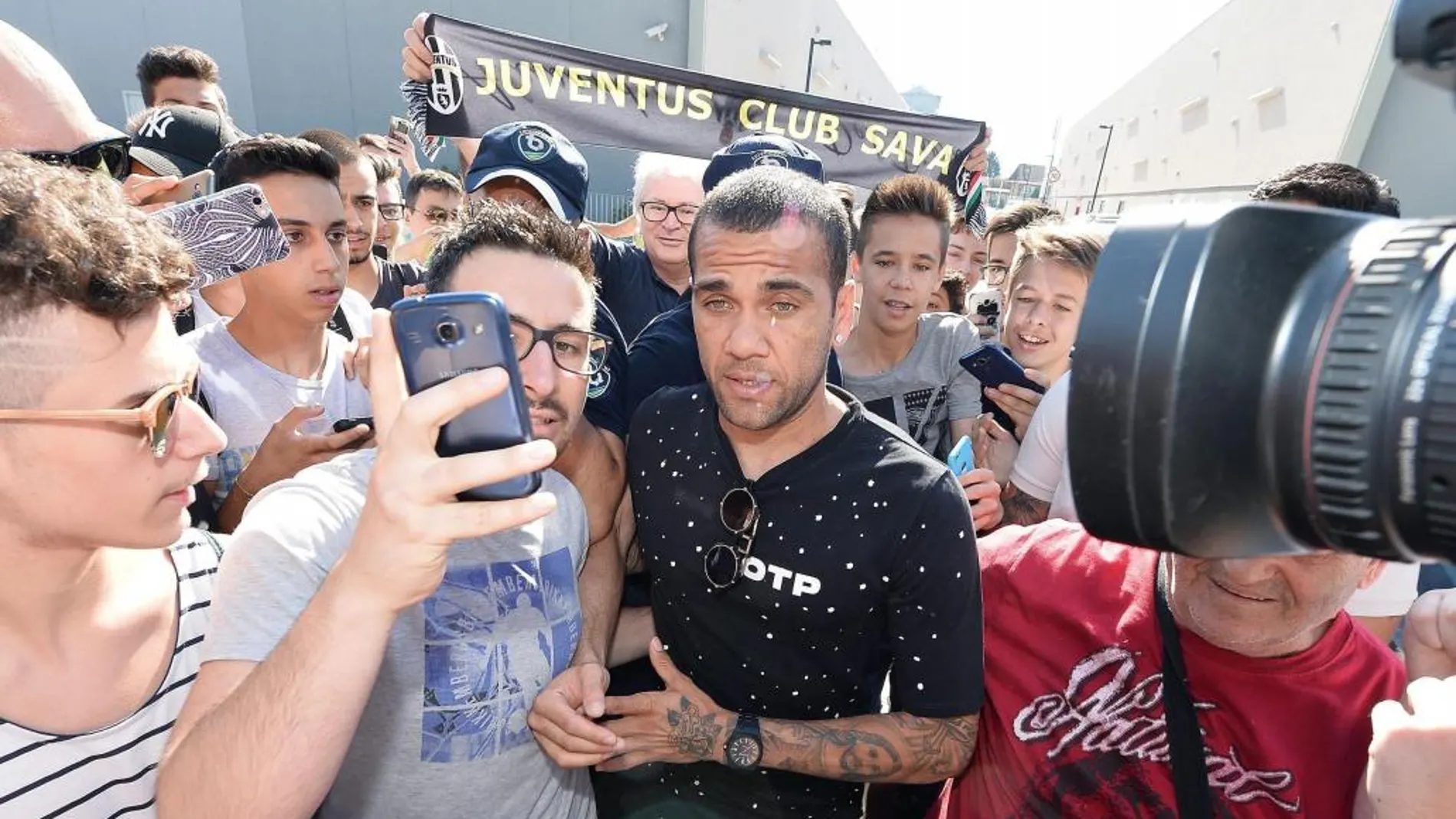 El nuevo futbolista brasileño del Juventus Dani Alves posa con los fans que le aguardaban a su llegada al centro J Medical, donde pasó el correspondiente reconocimiento médico.