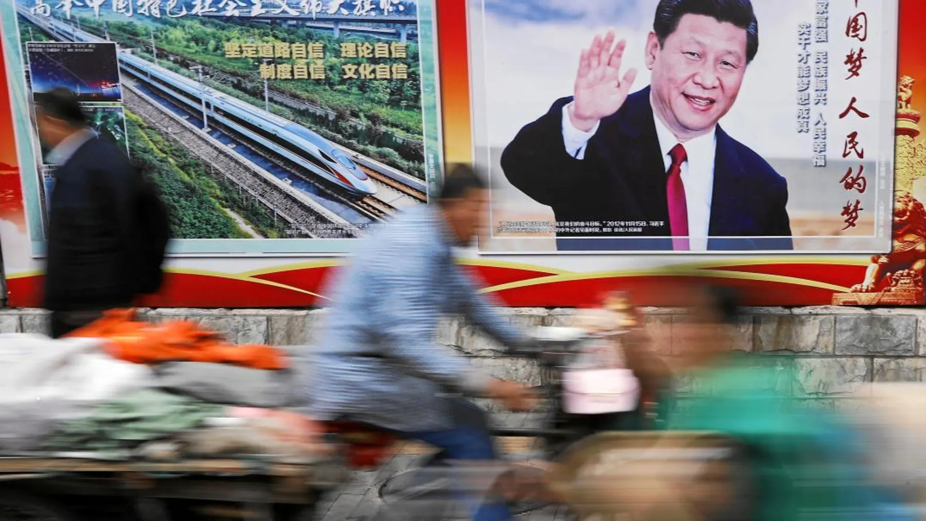 Carteles de Xi Jinping y de un moderno tren de alta velocidad en una calle de Pekín