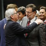El presidente del Gobierno español, Mariano Rajoy (d), saluda al presidente de la Comisión Europea, Jean-Claude Juncker, a su llegada a la cumbre extraordinaria