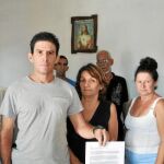 El disidente cubano Silvio Benítez y otros opositores posan con la carta enviada al Parlamento reclamando la libertad de movimiento en la isla