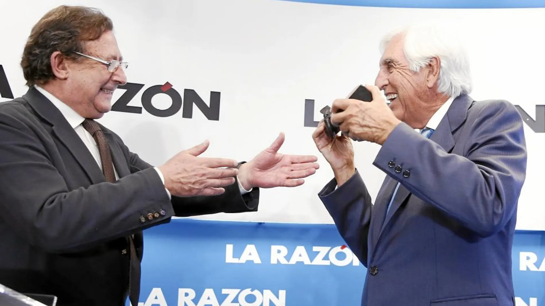Alfonso Ussía entrega el premio al presidente de la fundación, que muerde la estatuilla como Nadal
