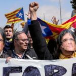 Manifestantes independentistas con caretas de Puigdemont, exigen su investidura