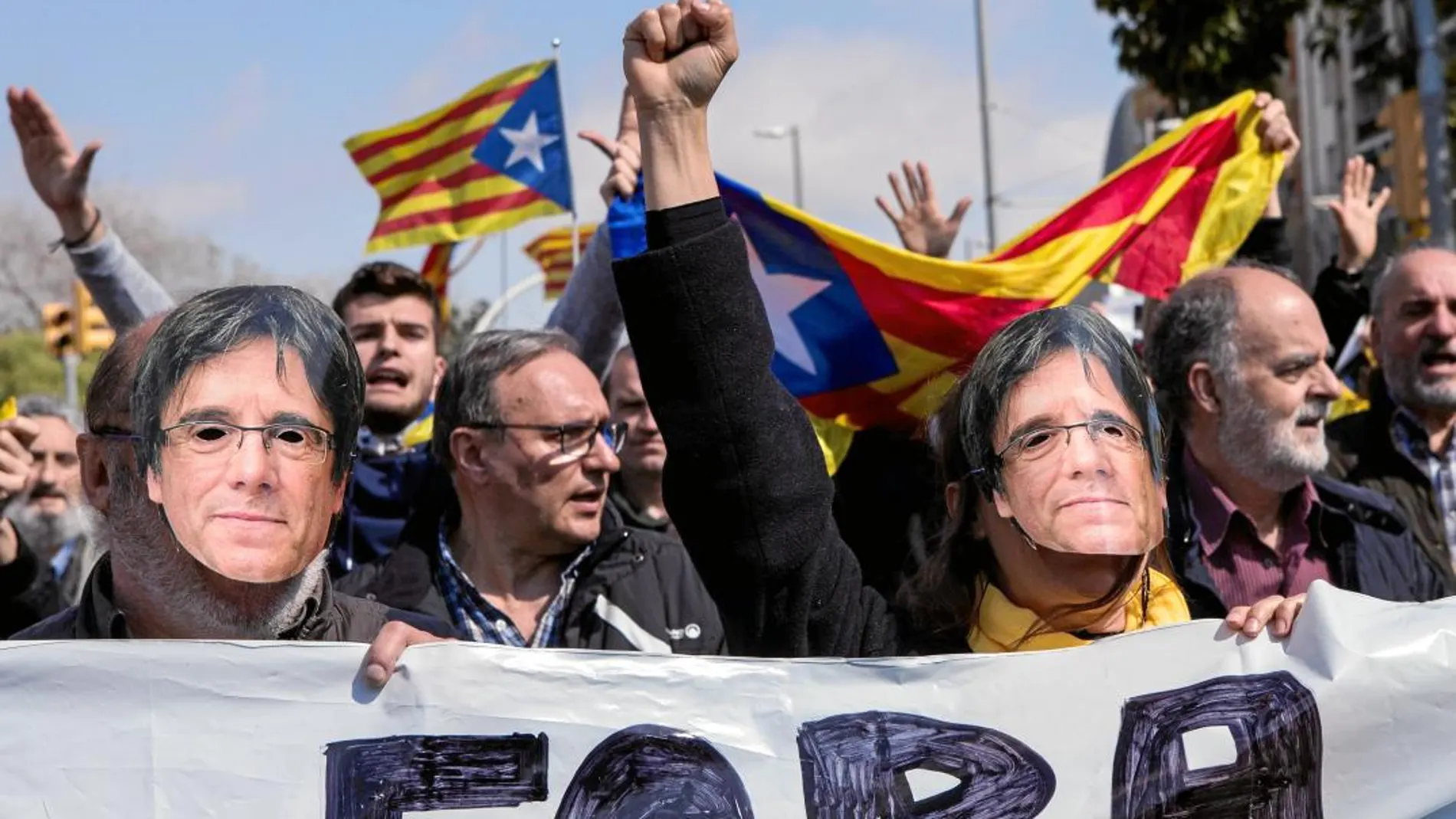 Manifestantes independentistas con caretas de Puigdemont, exigen su investidura
