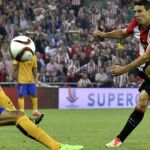 El delantero del Athletic, Aritz Aduriz (d), golpea el balón consiguiendo el tercer gol del equipo bilbaino
