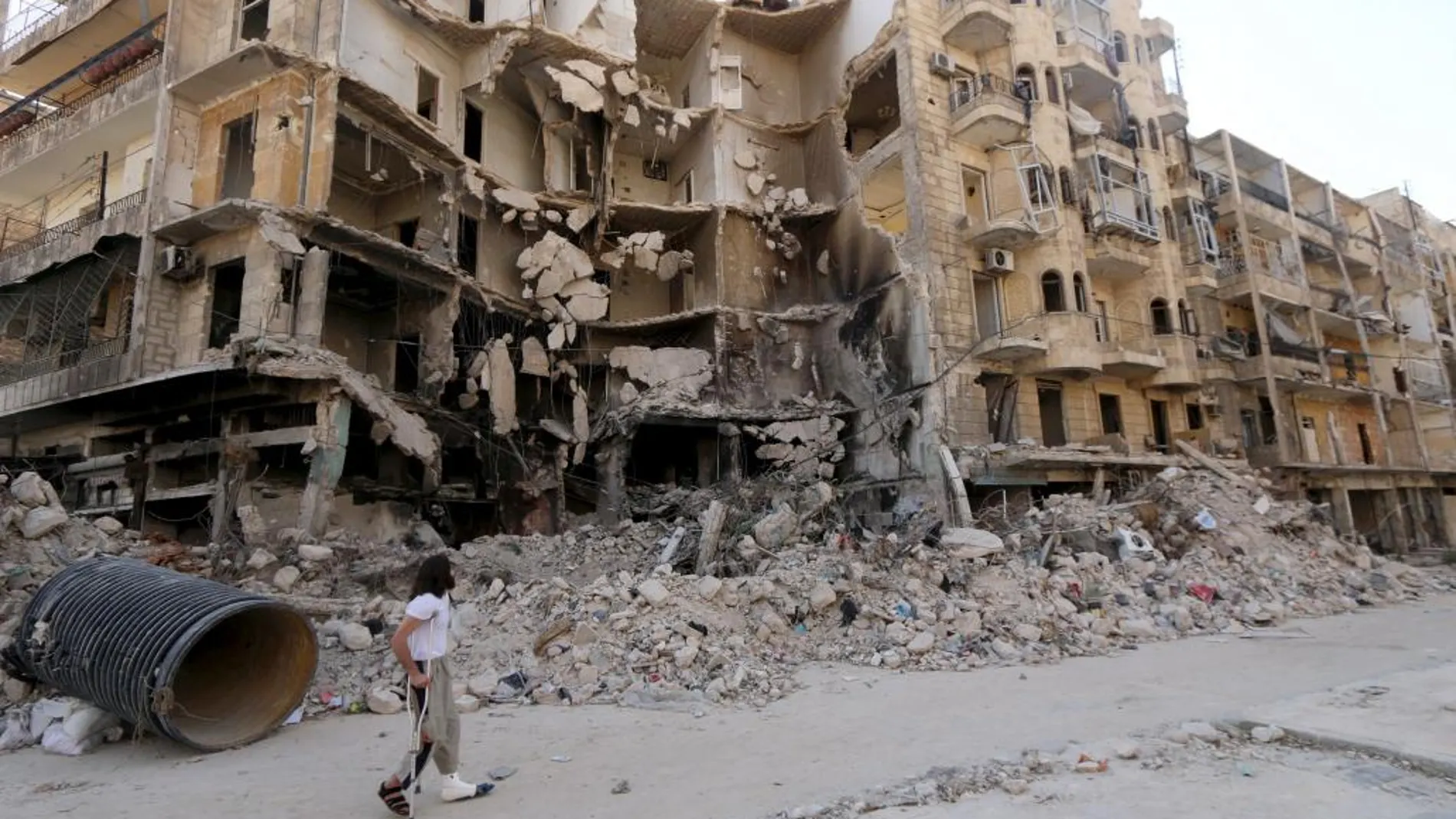 Un hombre pasa delante de edificio dañado por bombardeos en Aleppo