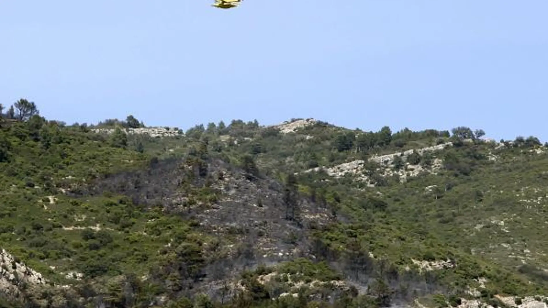 Un hidroavión sobrevuela las inmediaciones del lugar en el que se ha producido un accidente de una avioneta de la empresa Avialsa que trabajaba en la extinción de un incendio entre La Sènia (Tarragona) y Tinença de Benifassà (Castellón)