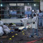 Varios policías inspeccionan el área de la explosión causada por el ataque suicida