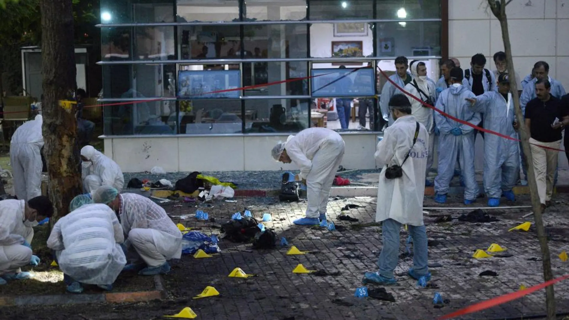 Varios policías inspeccionan el área de la explosión causada por el ataque suicida