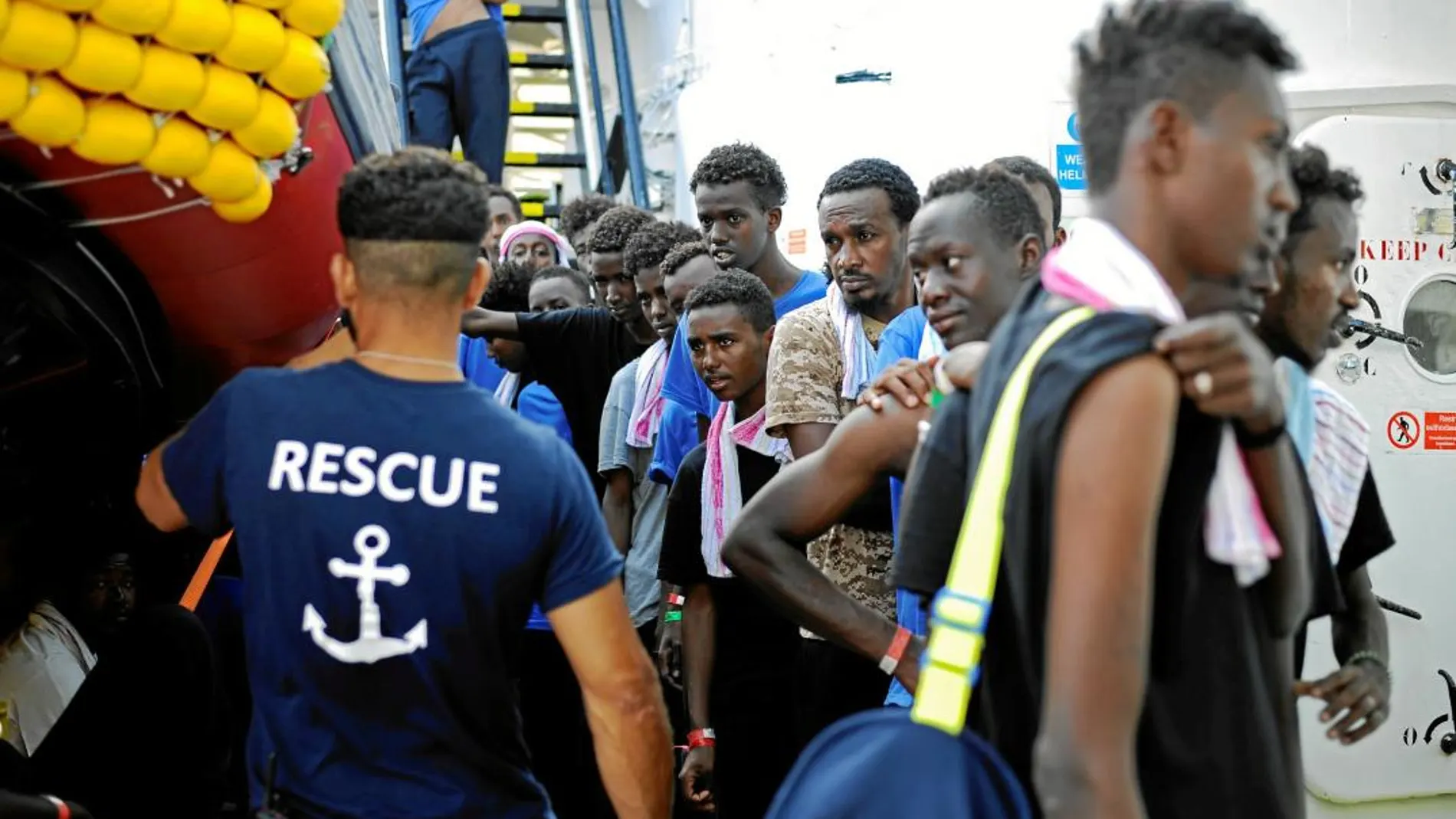 Un grupo de migrantes del «Aquarius» esperan a bordo del barco para recibir comida