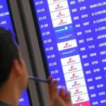 Un hombre observa la pantalla de información de vuelos en el aeropuerto de Barajas