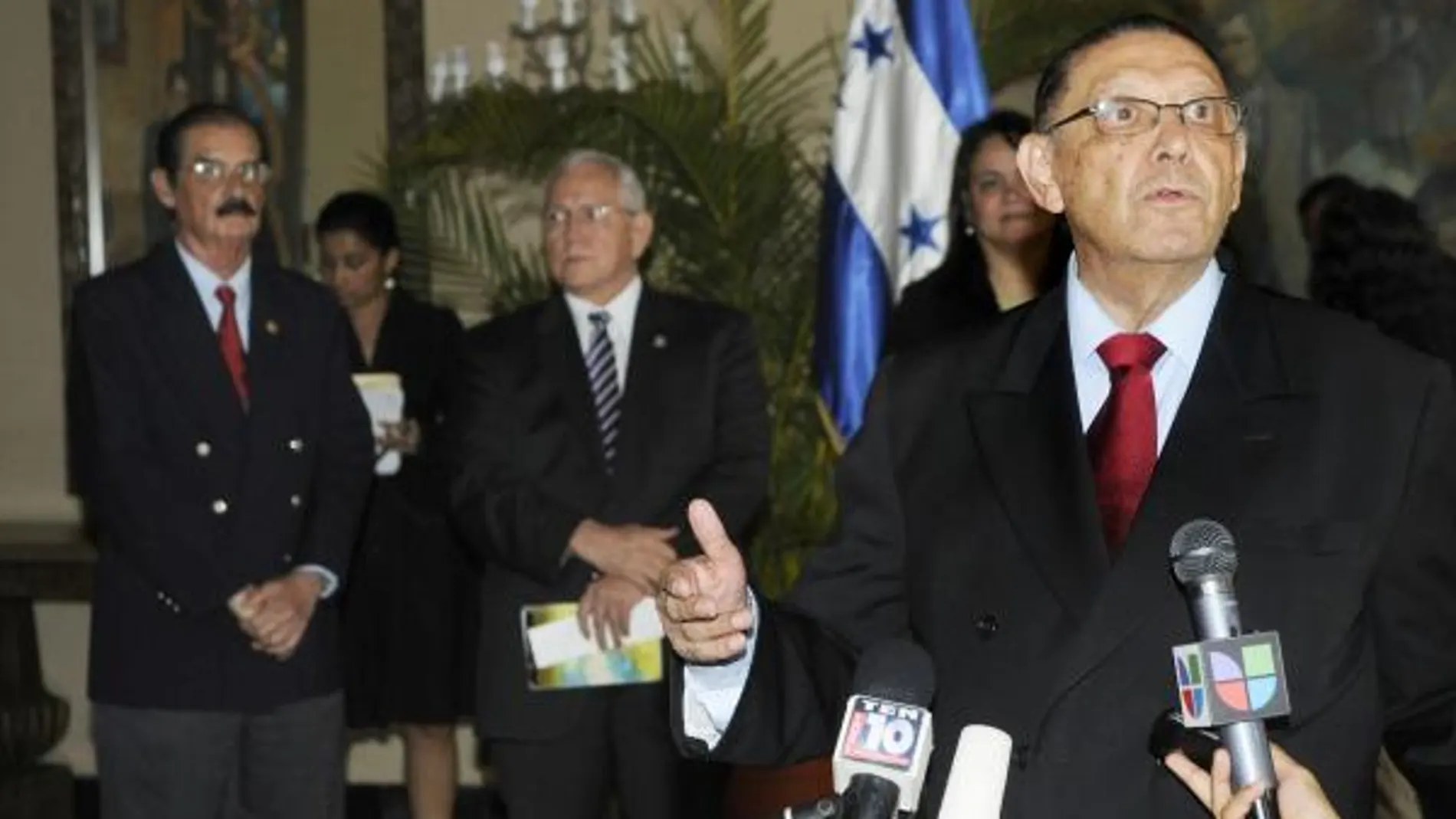 El nuevo ministro de Relaciones Exteriores hondureño, Enrique Ortez Colindres (d), habla con los medios