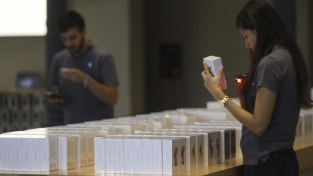 Una vendedora escanea uno de los modelos de Iphone 6s