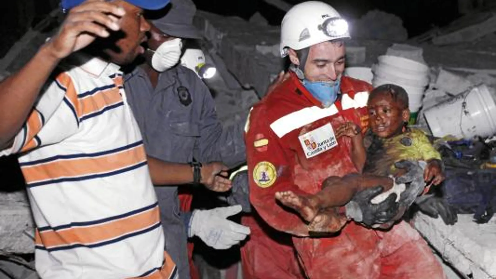 Uno de los bomberos de Castilla y León con el niño que rescataron del terremoto hace ya casi un año