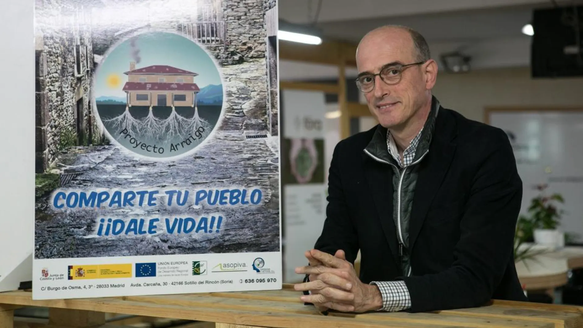 Enrique Martínez, uno de los promotores de la iniciativa, junto a un cartel promocional con el que anima a alquilar o vender viviendas para su uso como segunda residencia