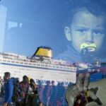 Un niño refugiado mira por la ventana del autobús tras llegar por ferry al puerto del Pireo en Atenas