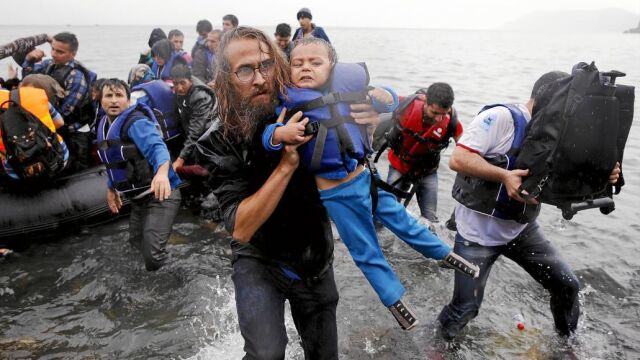 Un voluntario de una ONG atiende a un menor recién llegado a la isla griega de Lesbos procedente de Turquía