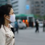 Una mujer con mascarilla para protegerse de la polución