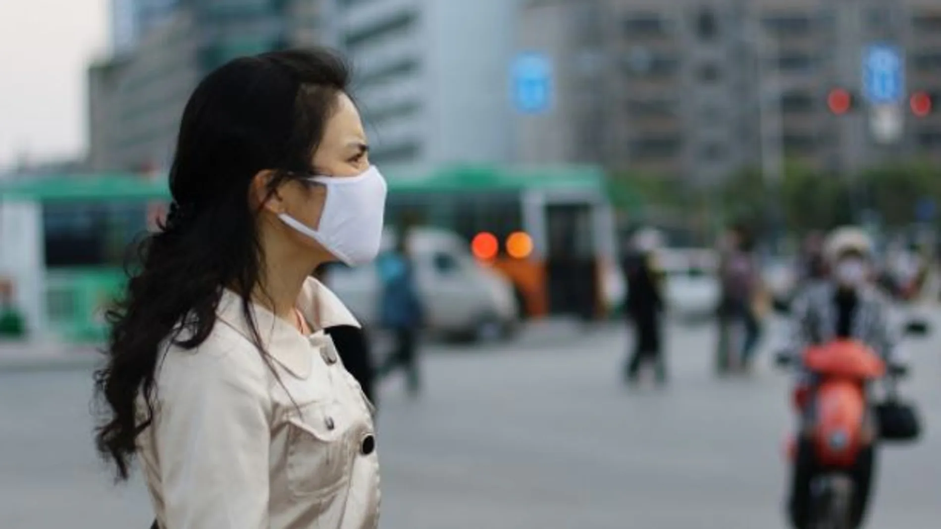 Una mujer con mascarilla para protegerse de la polución