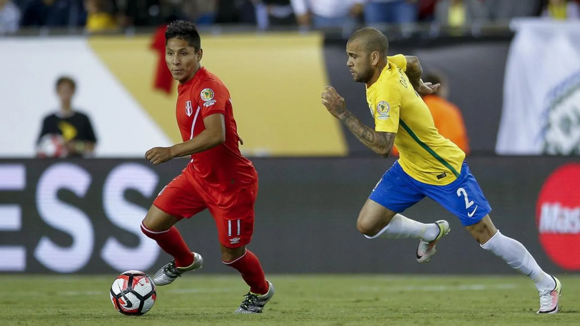 Raúl Ruidiaz (i) de Perú disputa un balón con Dani Alves (