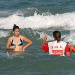 Una socorrista advierte a una bañistas en una playa de Alicante