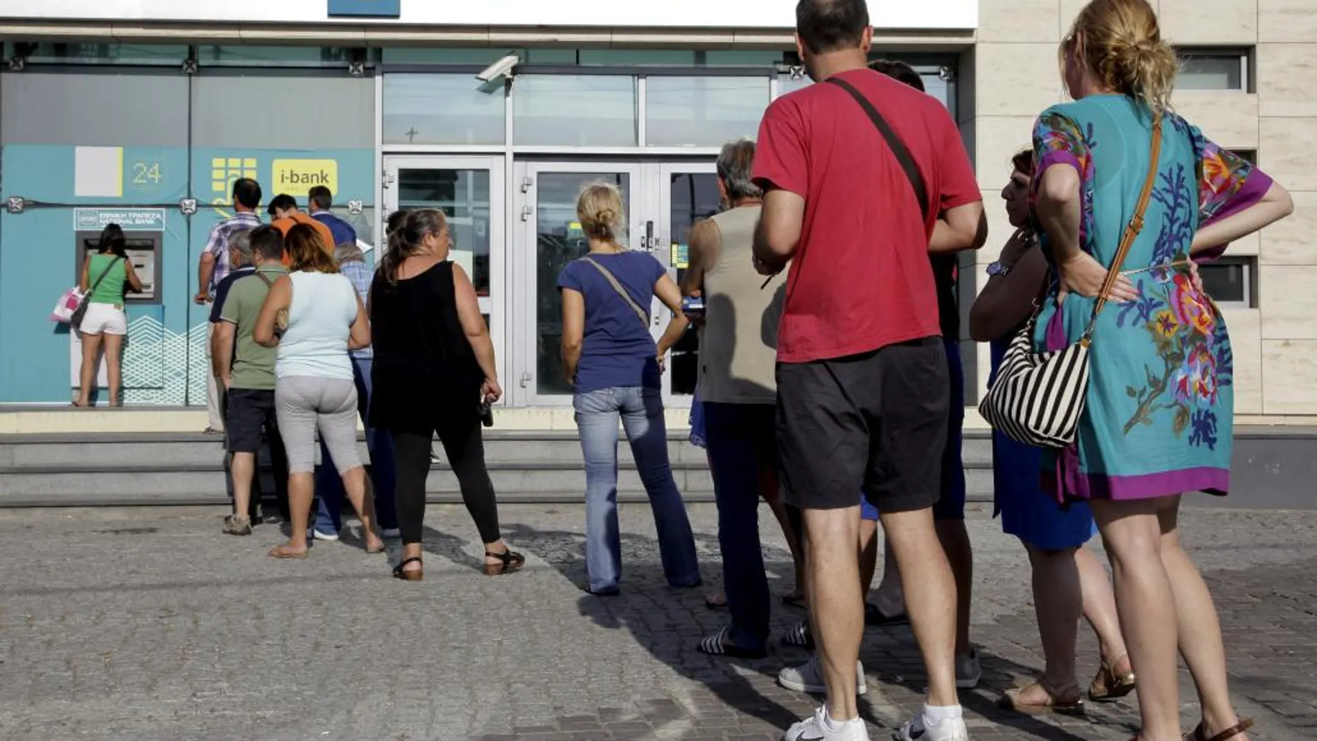 Fila de ciudadanos ante un cajero automático en Creta.
