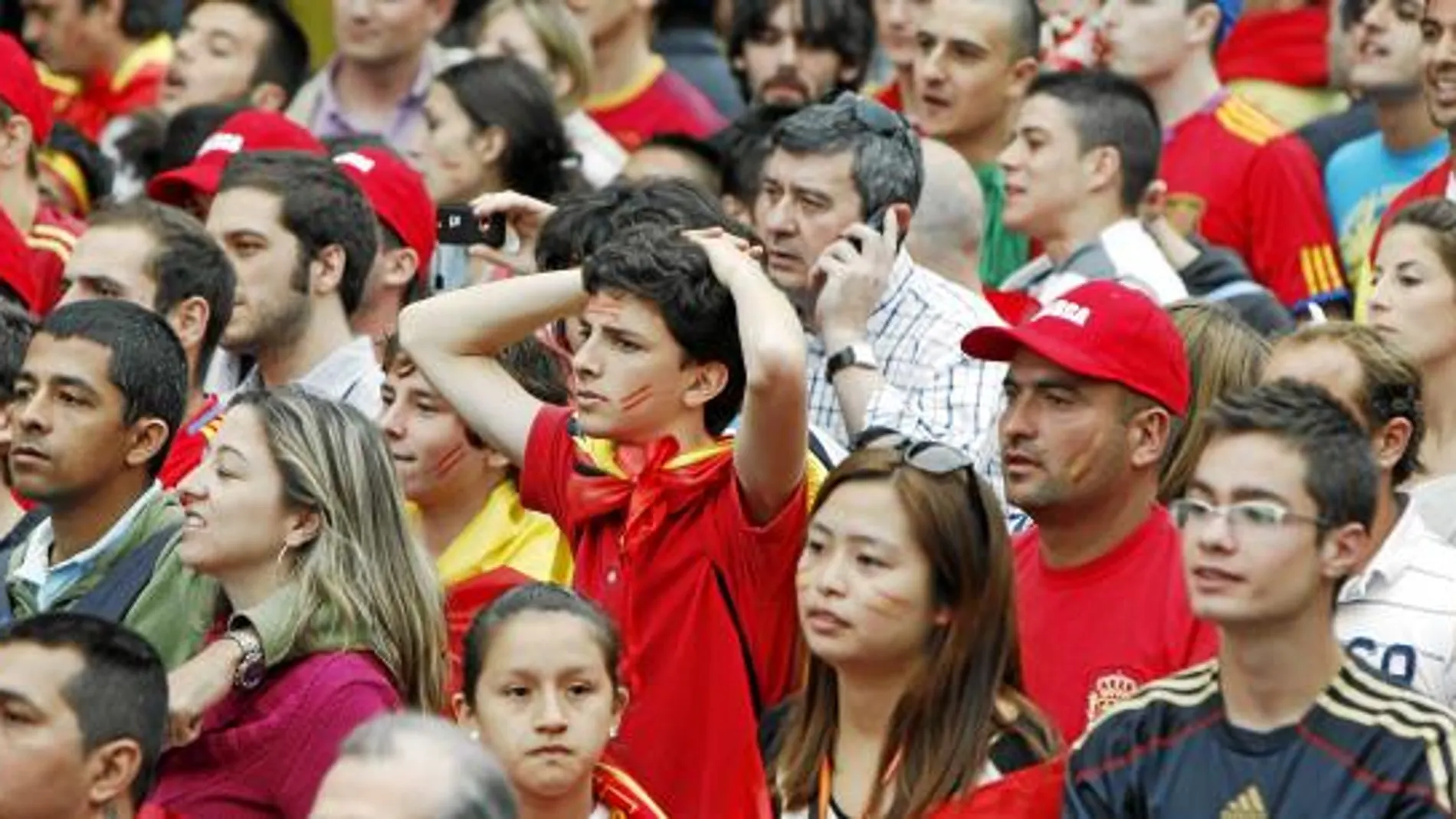 Rostros de tensión de la afición durante el partido de España frente a Suiza, en el estacionamiento del Bernabéu