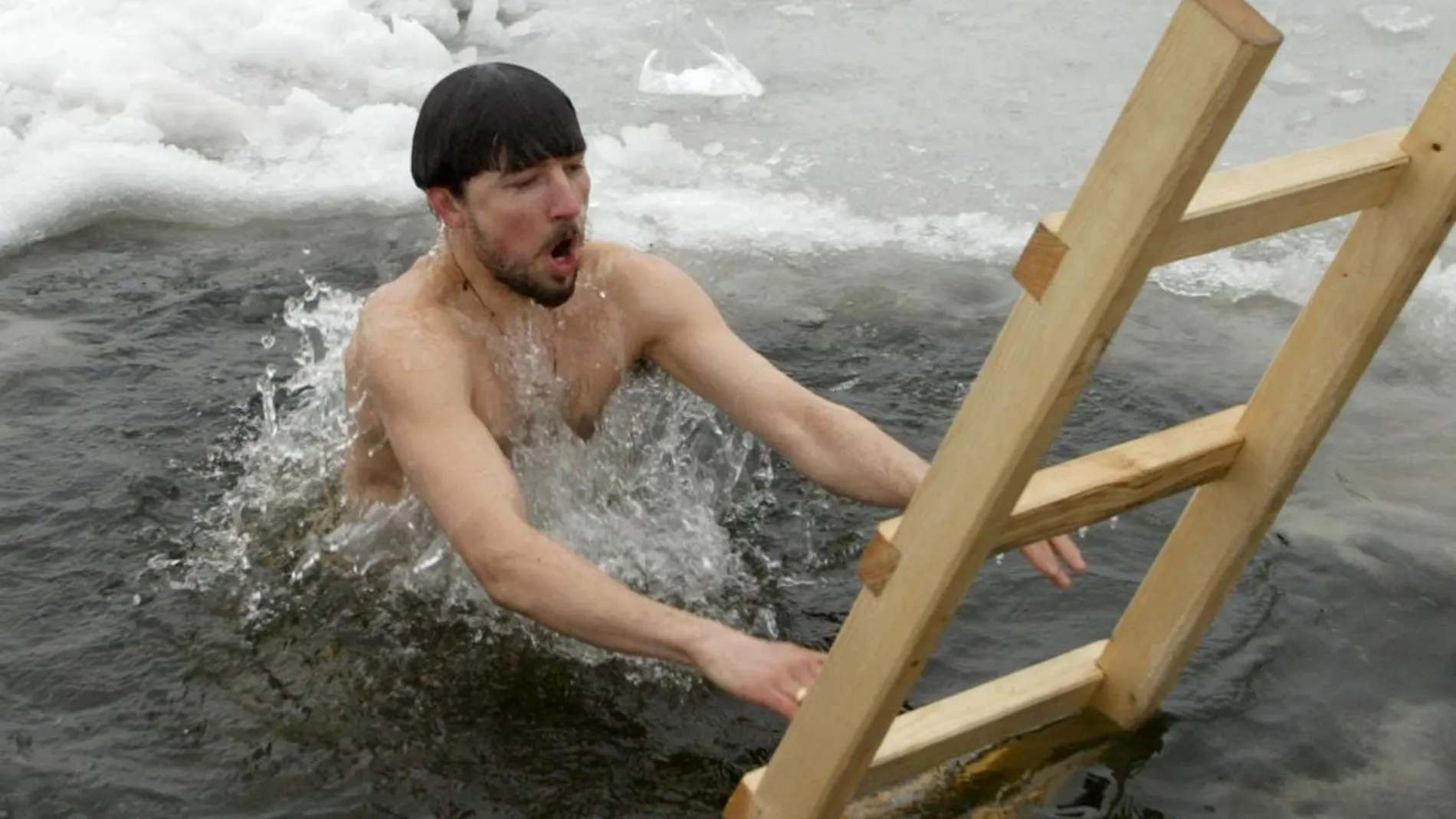 Un hombre se baña en agua helada en un lago a las afueras de Moscú
