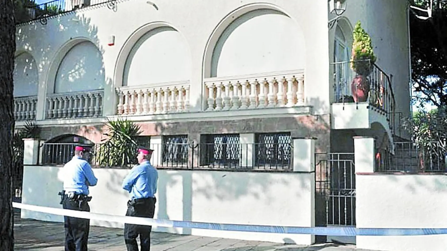 En la imagen, dos agentes de los Mossos, frente a la casa donde falleció el empresario Jordi Comas en un asalto