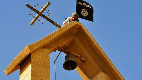 Un terrorista coloca una bandera de Estado Islámico en Mosul