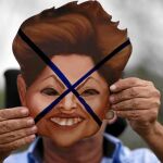 Un manifestante protesta con una careta de la presidenta brasileña