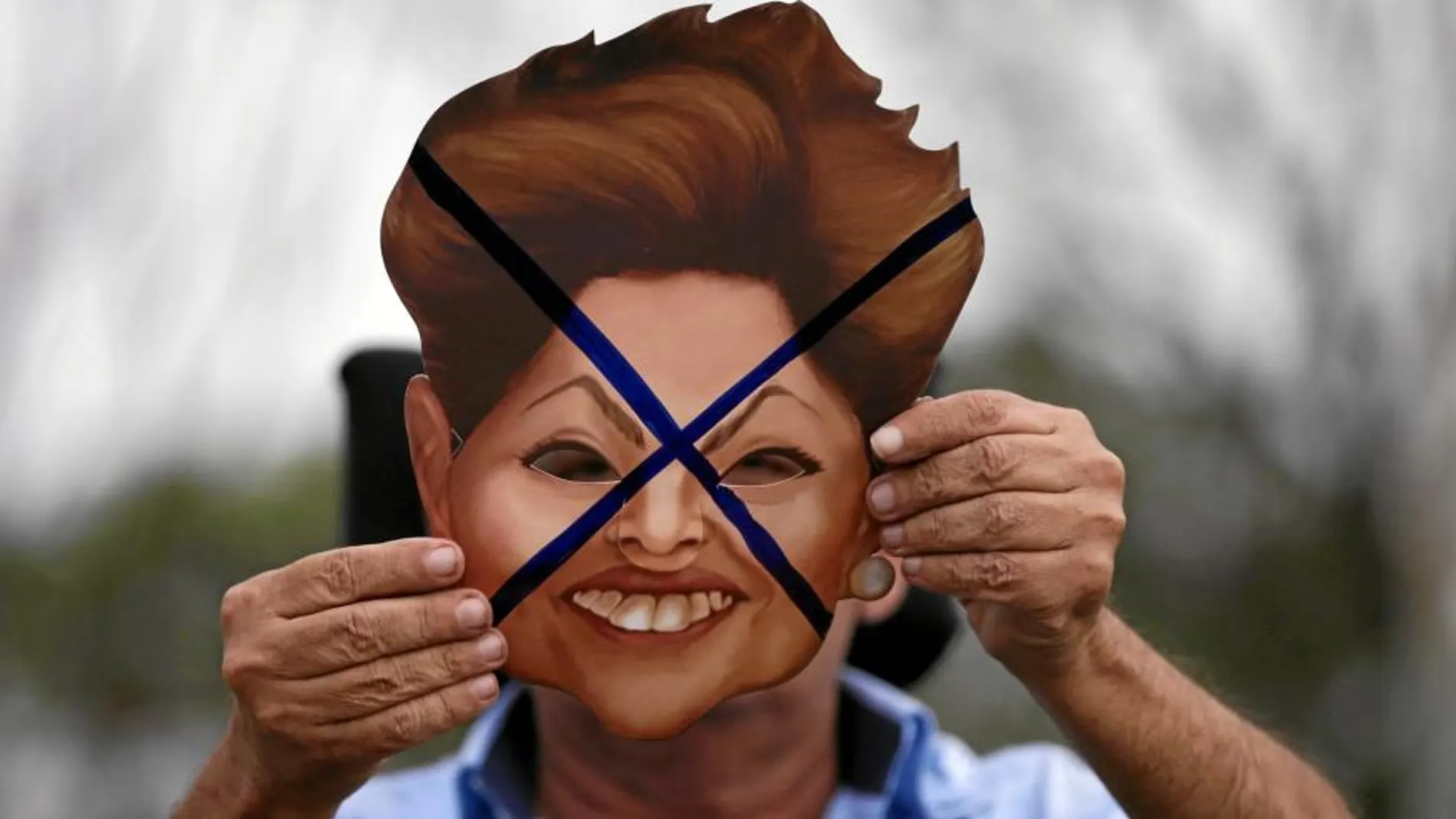 Un manifestante protesta con una careta de la presidenta brasileña
