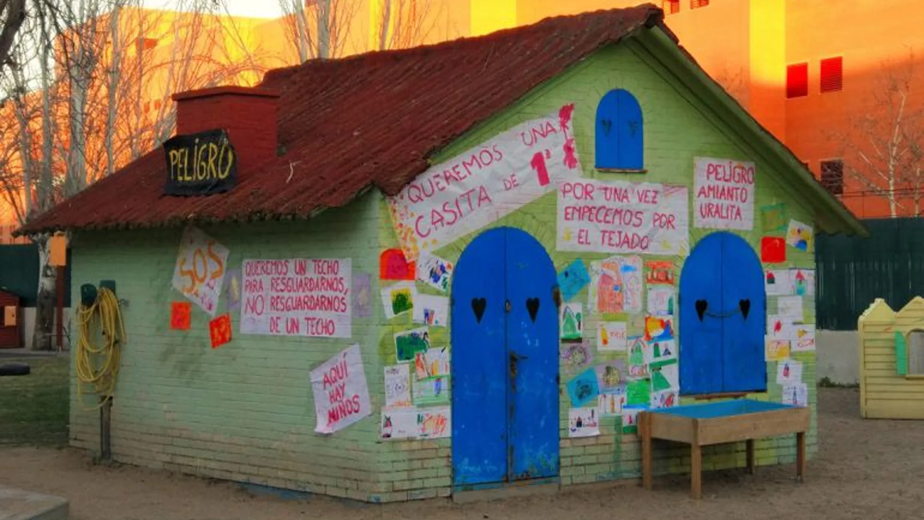 La casita del patio de la Escuela infantil Jeromín de Leganés amanece desde hace meses con carteles exigiendo su retirada porque en su tejado, en la que deberían jugar niños, hay partículas de amianto