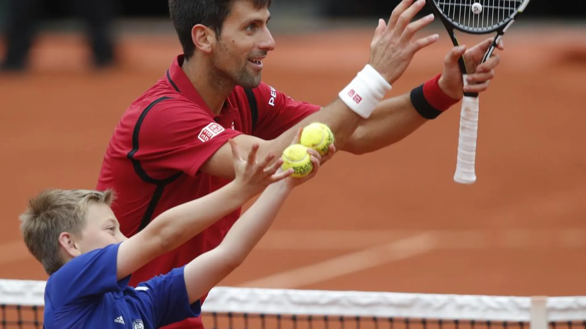 Djokovic celebra la victoria con un recogepelotas