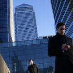 Un hombre consulta su móvil en el centro financiero de Londres