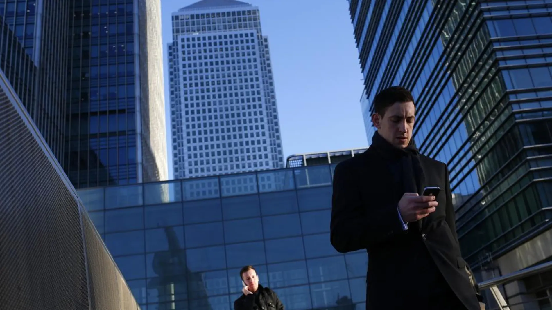 Un hombre consulta su móvil en el centro financiero de Londres