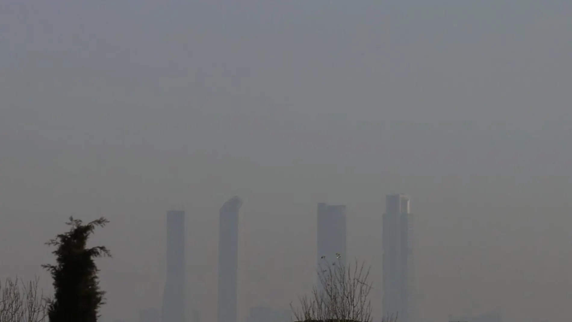 Las Cuatro Torres de Madrid apenas se vislumbran debido a la capa de contaminación, en una imagen de archivo
