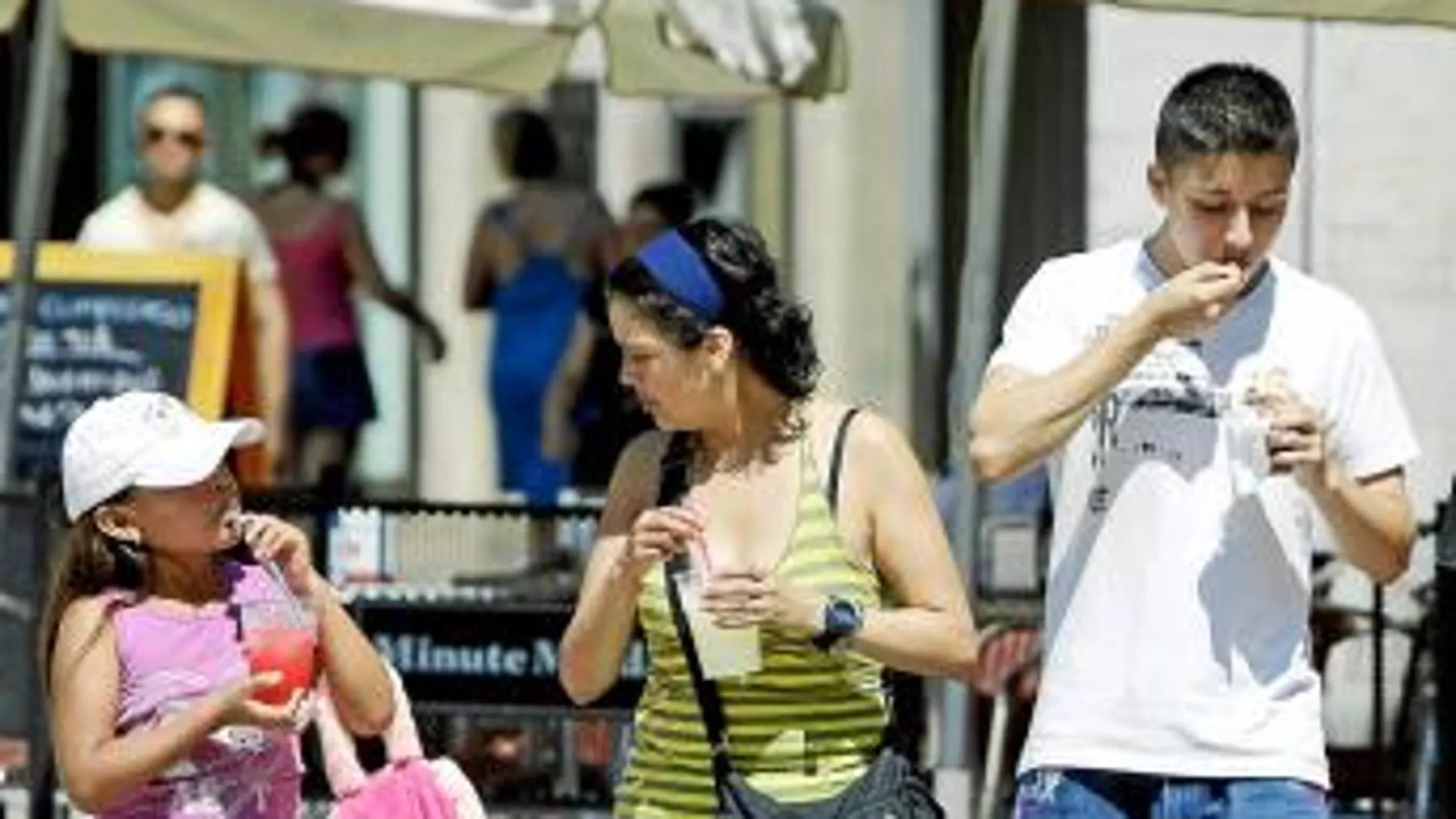 Una familia se refresca con helados y granizados en la céntrica plaza de la Virgen de Valencia