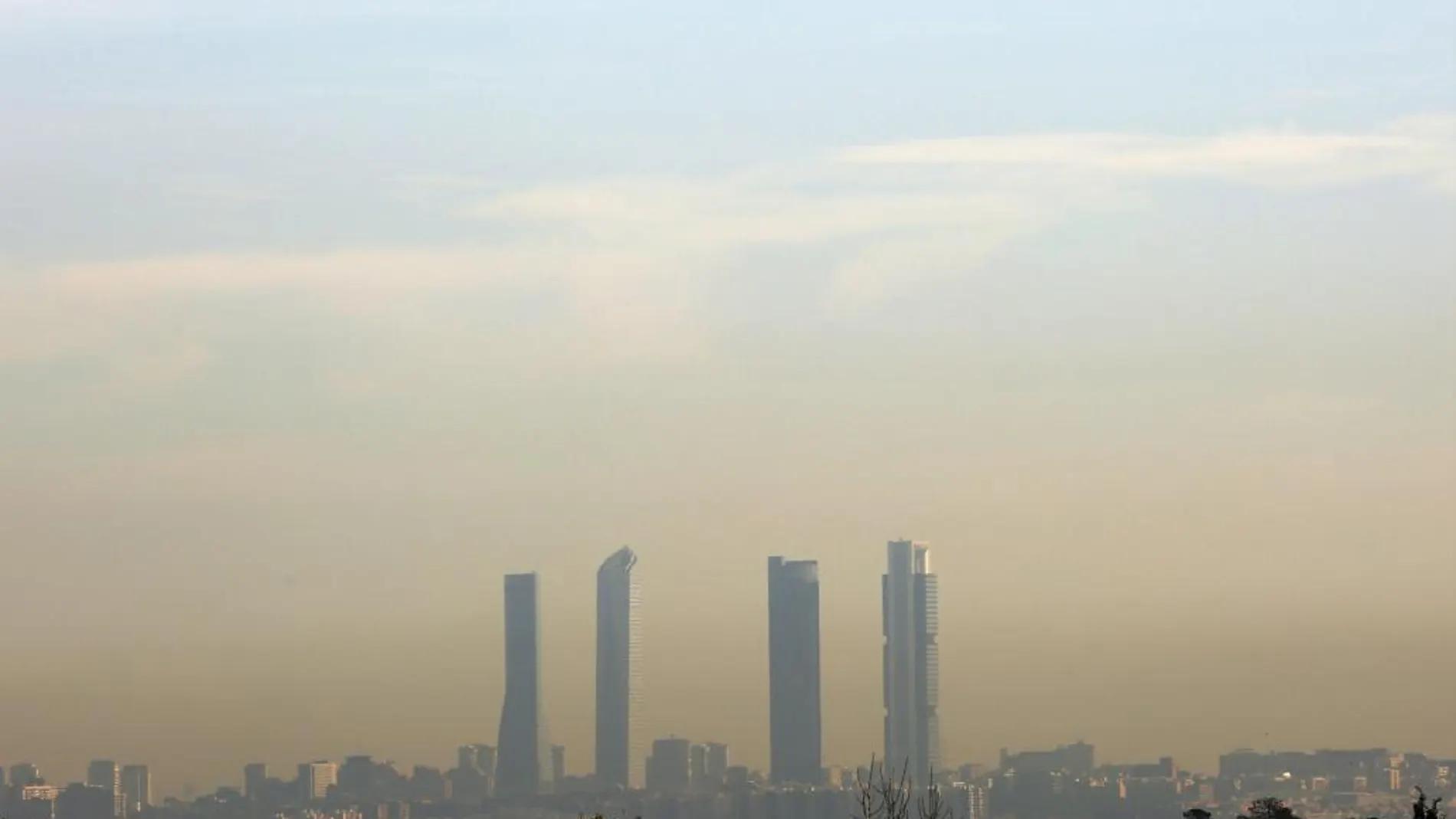 Las Cuatro Torres se perfilan entre la nube de polución de Madrid.