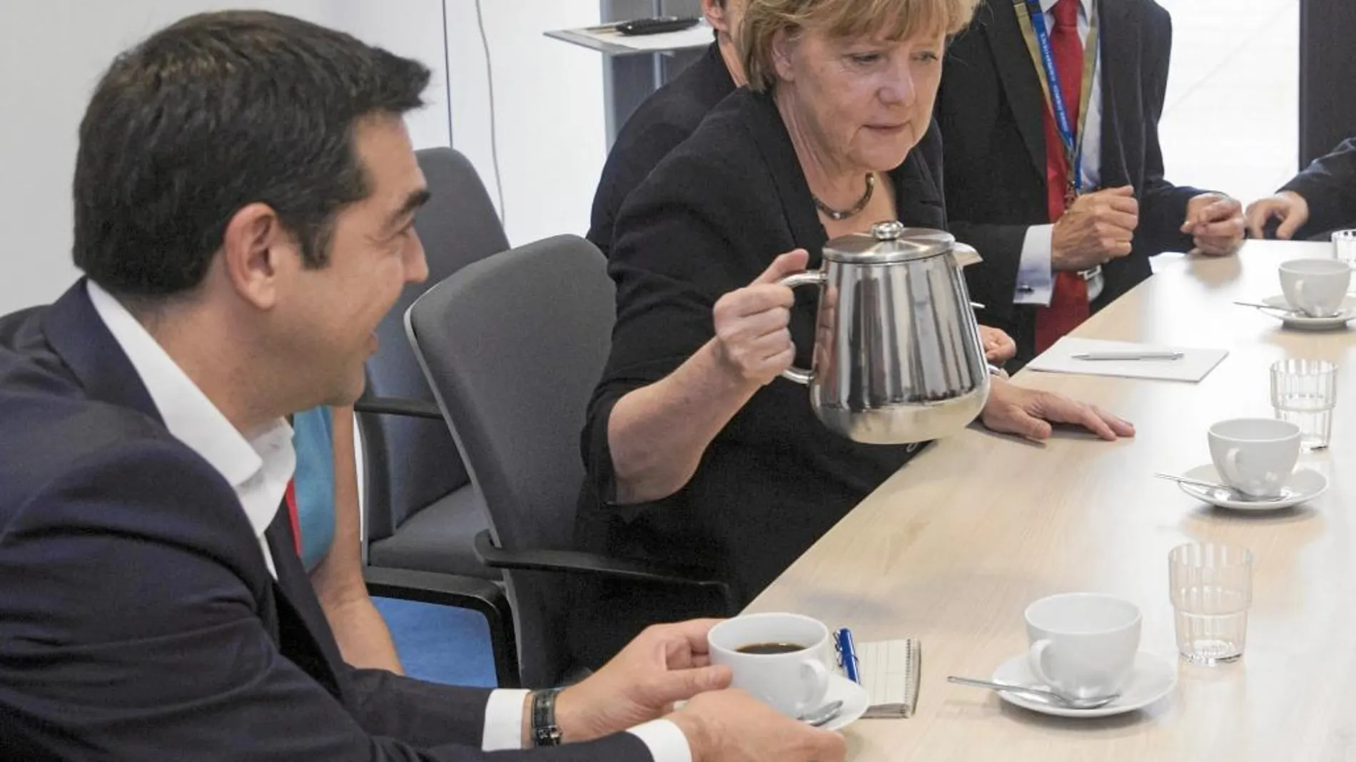 CAFÉ PARA TODOS. Angela Merkel sirve café a Alexis Tsipras, ayer, durante la reunión de líderes europeos en Bruselas