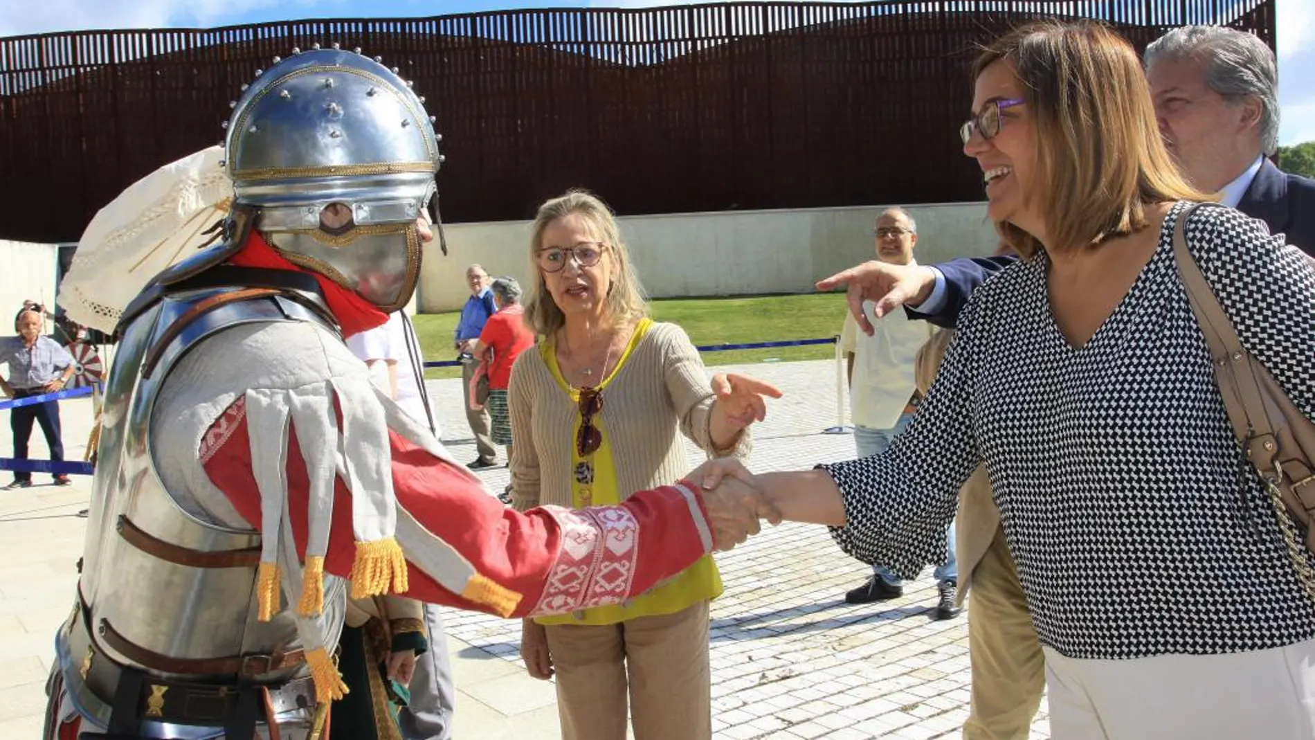 La presidenta de la Diputación, Ángeles Armisén, saluda a un soldado romano, en el acto central del 50 aniversario de la Villa Romana La Olmeda
