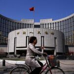 Una mujer pasa por delante del Banco Popular de China en Pekín