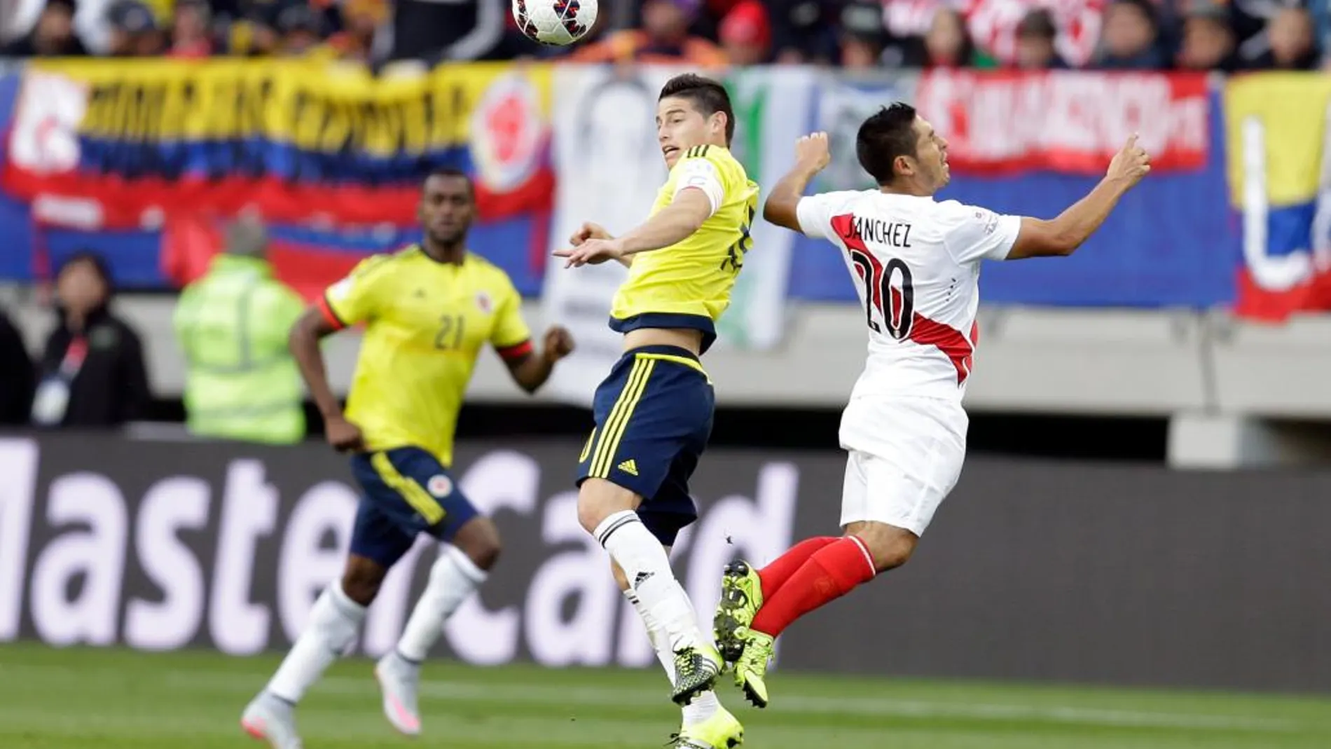 James Rodriguez, de Colombia, remata de cabeza ante el jugador de Perú, Joel Sanchez