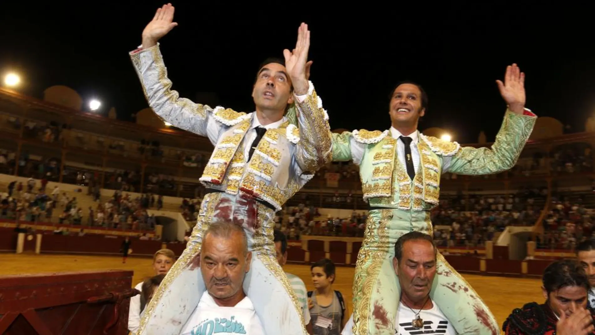 Los diestros Enrique Ponce (i) y David Mora salen a hombros tras el festejo taurino de Feria celebrado esta tarde en la plaza de toros de Almería.
