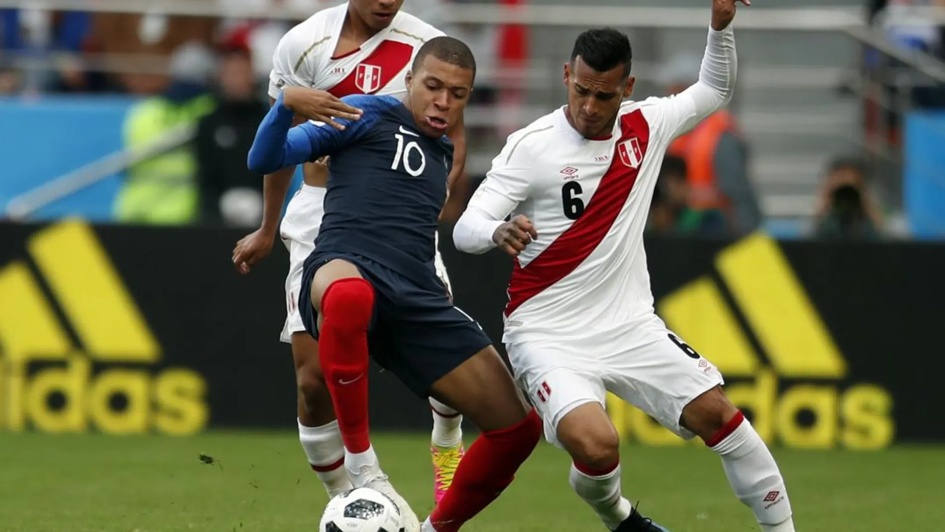 El francés Kylian Mbappe disputa un balón en presencia del peruano Miguel Trauco / Ap