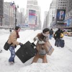 PERDIDOS EN LA NEVADA. Varios viajeros acarrean sus equipajes, ayer, en la Séptima Avenida