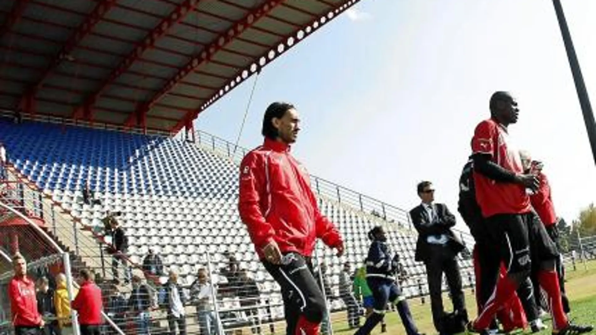 Hakan Yakin salta al campo de entrenamiento junto a Nkufo, con Behrami por detrás